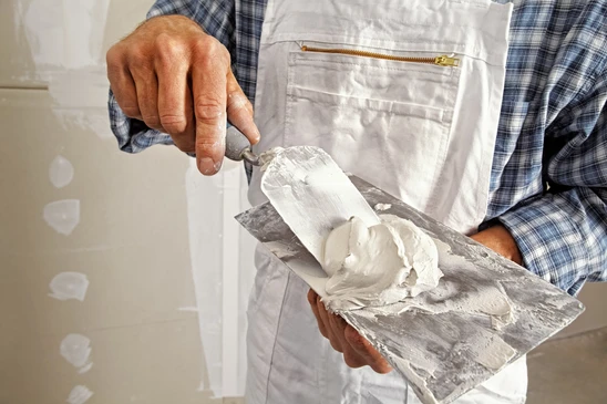 Intérieur professionnel avec ouvrier effectuant ponçage de parquet en bois massif
