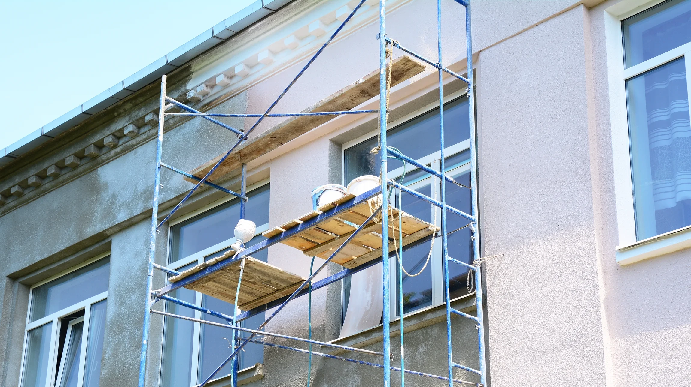Maison abandonnée isolée dans paysage rural aride sous ciel orageux dramatique