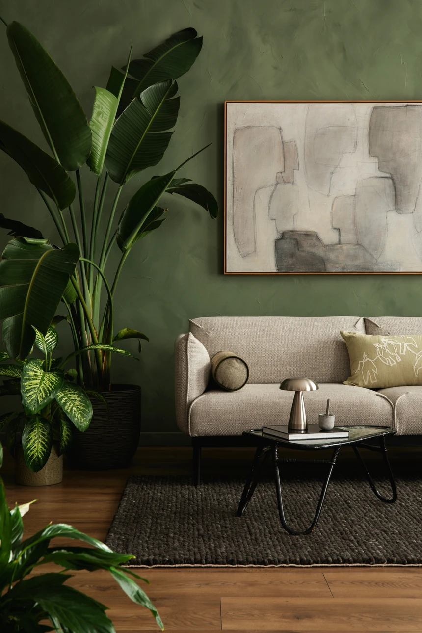 Deux hommes installent du papier peint à motifs ornementaux beige dans un intérieur résidentiel avec moulures blanches